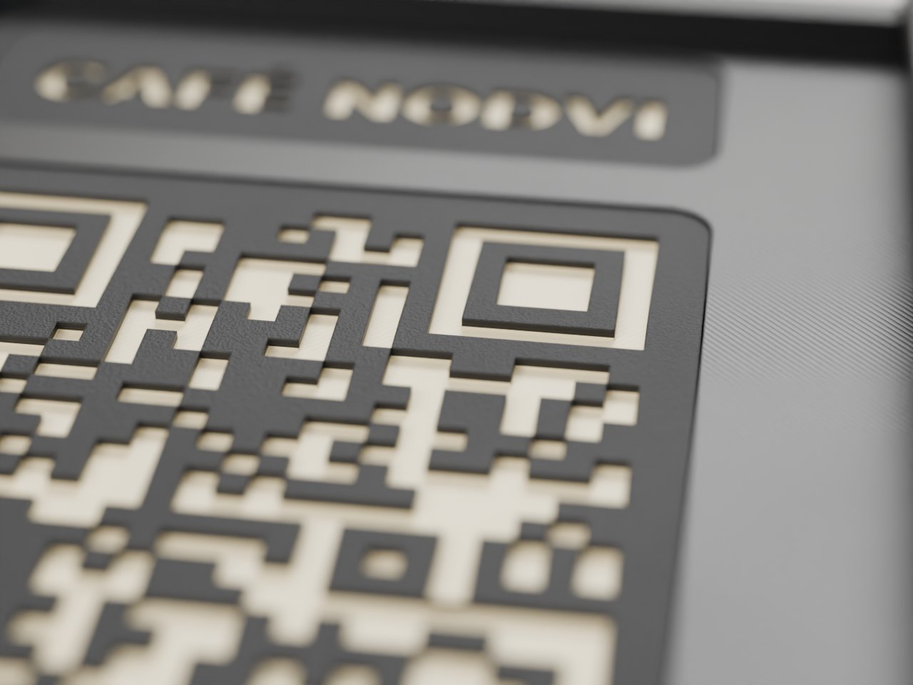 Detalle del grabado: módulos del QR hundidos 0,8 mm con fondo crema sobre la cara negra texturizada